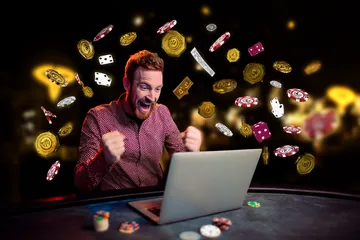 A man celebrating a winning moment on his laptop while gaming symbols float around him, capturing the excitement of 4777GEM games.
